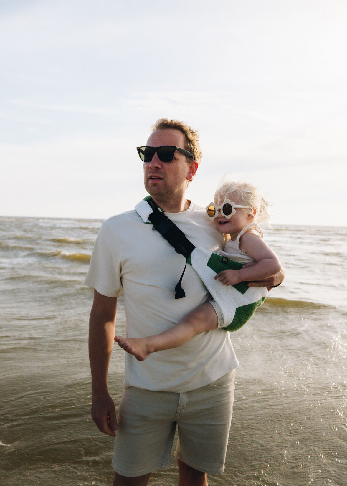 Hands free toddler carrier worn by dad at the beach, comfortable toddler hip carrier